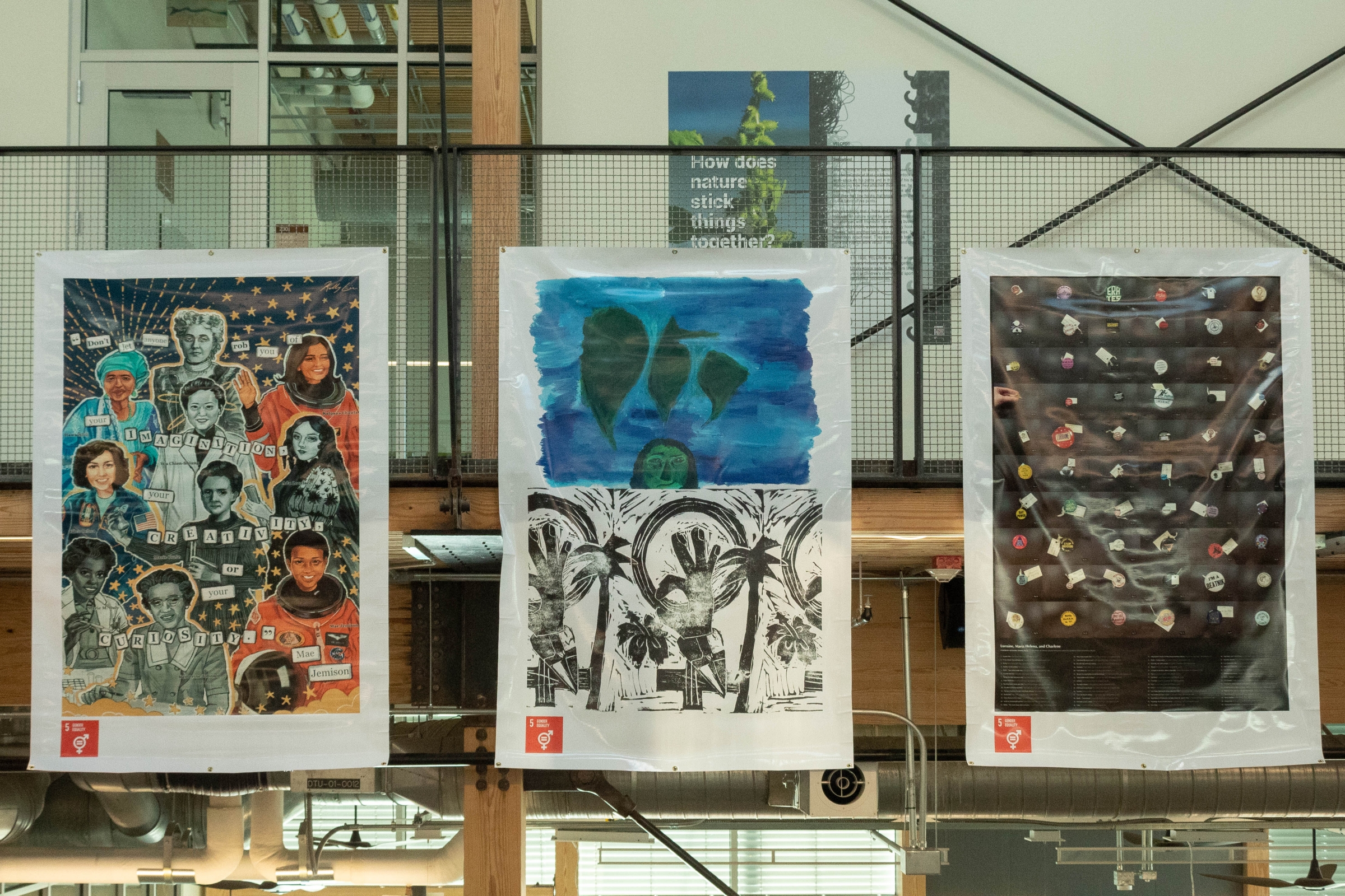 Banners from left to right: “The Named Pioneers” by Kelly Lin, “Pensamientos Isleños, and Tropical Feminism” by Alexandra Rodriguez Dalmau, and “Lorraine, Maria Helena, and Charlene” by Alexandra Teixeira Riggs hanging from the second-floor of The Kendeda Building.